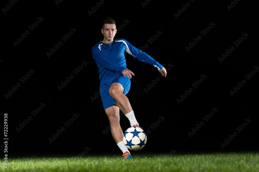 Professional Soccer Player Kicking Ball Isolated On Black