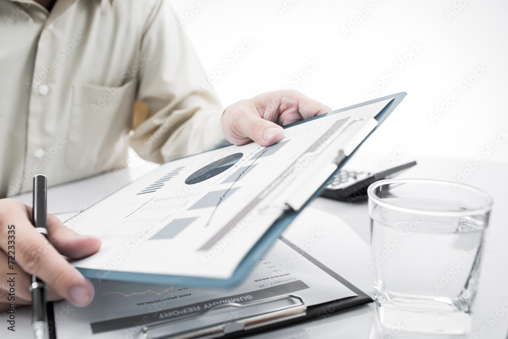 Fototapeta premium Close-up of graphs and charts analyzed by businessman
