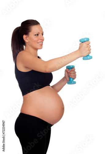 Brunette pregnant woman training with dumbbells © Gelpi
