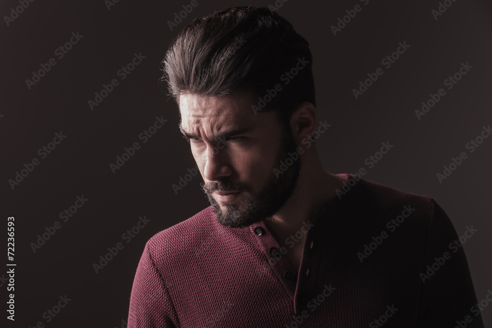 casual young man looking angry away from the camera casual young man looking angry away from the camera