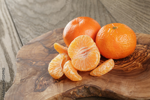 ripe tangerines on olive board