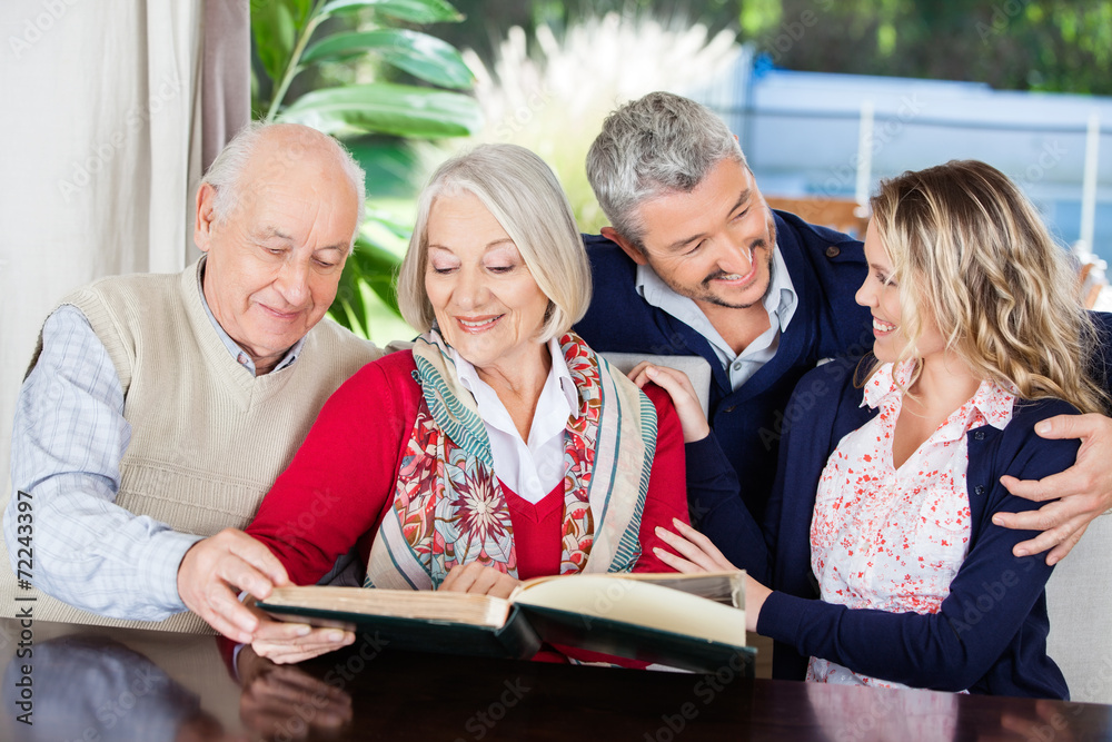 Happy Senior Couple Reading Book With Grandchildren In Nursing H Happy Senior Couple Reading Book With Grandchildren In Nursing H