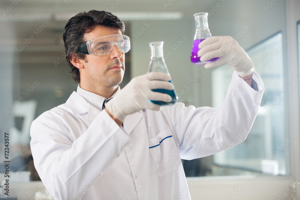 Researcher Examining Flasks With Different Samples Researcher Examining Flasks With Different Samples
