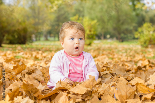  baby playing with autumn leaves