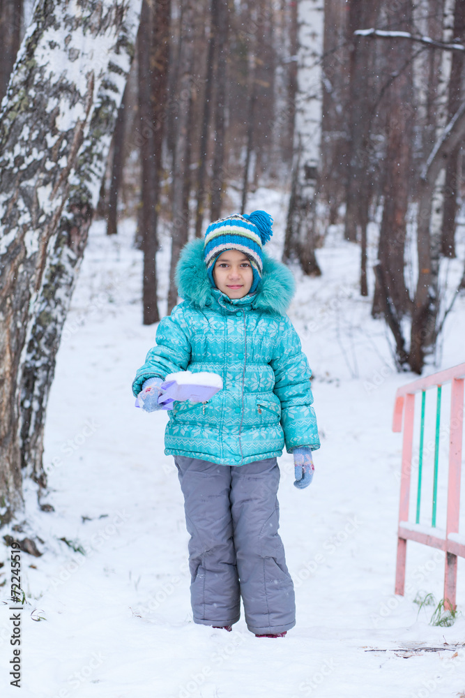 Happy kid girl child winter digging snow with toy spade