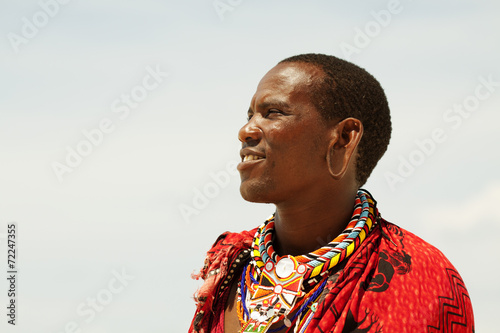 Young massai warrior man posing on bright sunny beach in Kenya photo