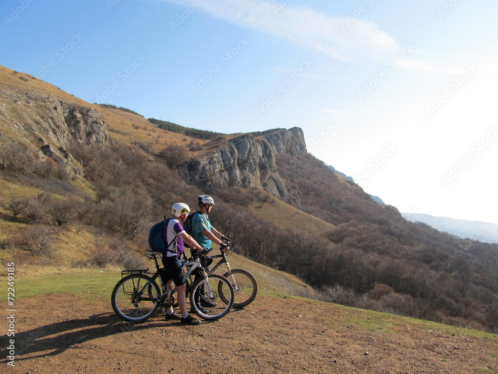 Young athlete standing on a rock with bicycle Young athlete standing on a rock with bicycle