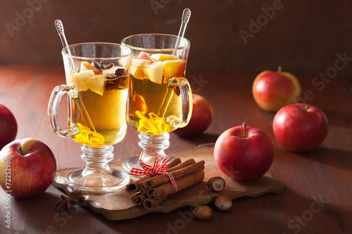 glass of mulled apple cider with orange and spices, winter drin