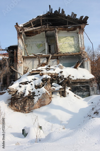 Deserted and a demolished old brick house in the winter city