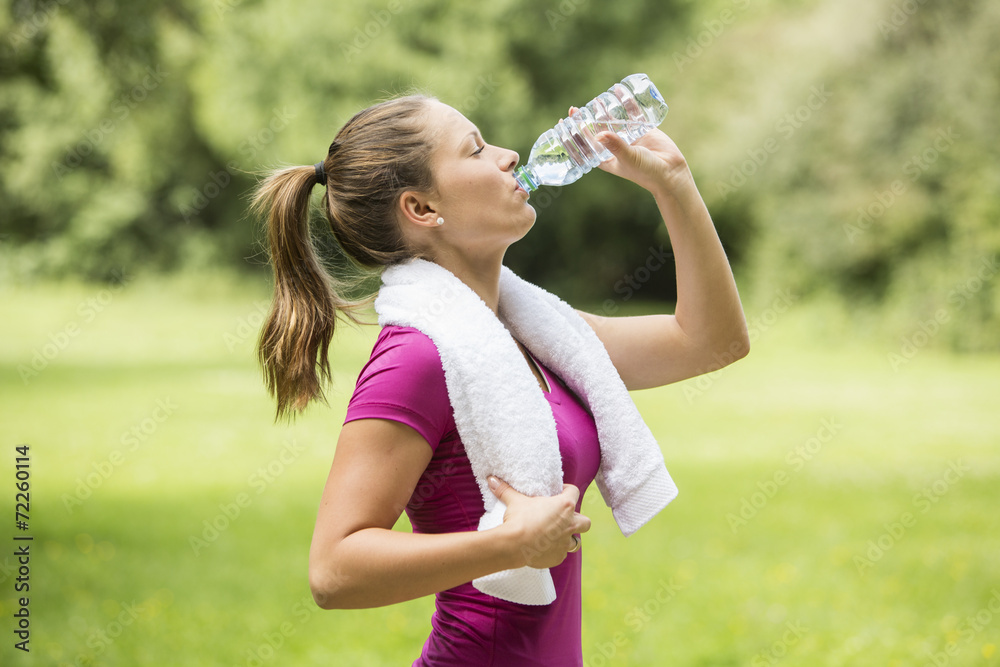 Athletic young woman drinking bottled water Athletic young woman drinking bottled water