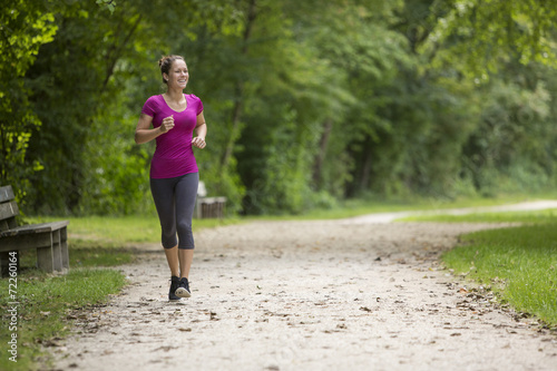 Fototapeta Naklejka Na Ścianę i Meble -  Fit young woman jogging in a park