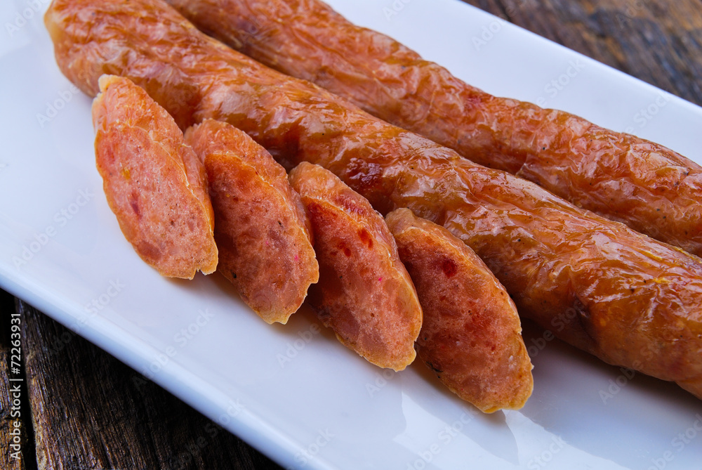 Chinese Pork Sausages in plate on wooden table Chinese Pork Sausages in plate on wooden table
