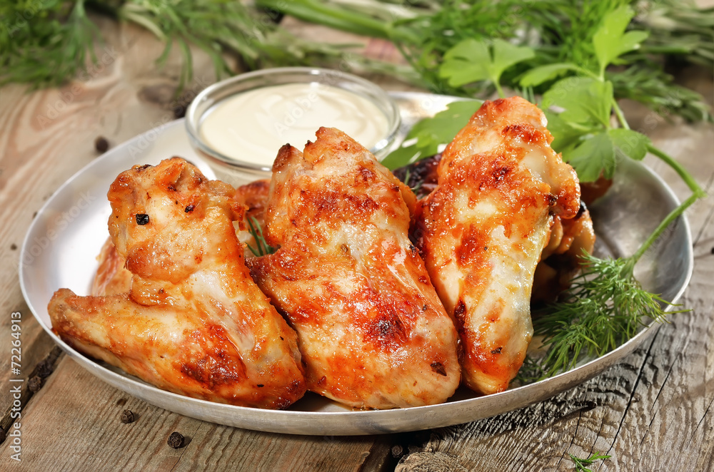 Baked chicken wings with sauce on wooden table Baked chicken wings with sauce on wooden table