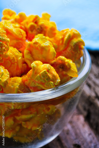 Cheese flavored popcorn in bowl on wooden table