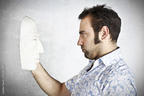 Man looking to a plaster mask