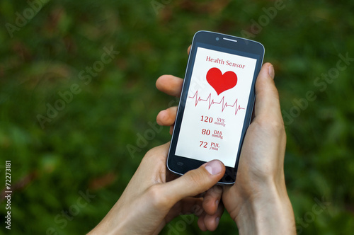 Male hand holding a phone with pressure and heart rate screen