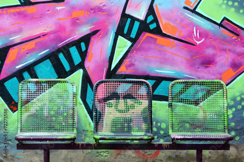 Street chairs in front of graffiti wall