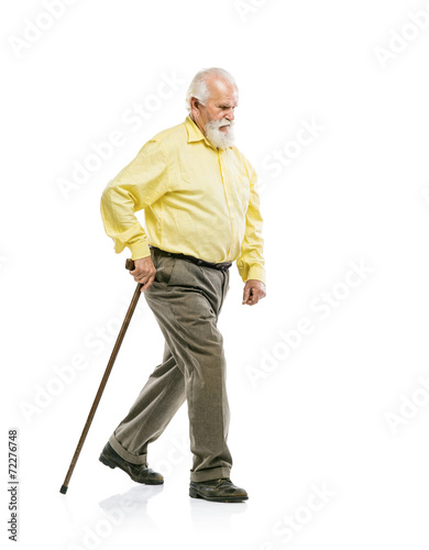 Old bearded man walking with cane