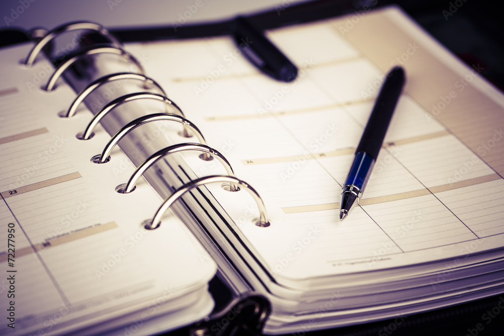 Personal organizer or planner with pen on white background Personal organizer or planner with pen on white background
