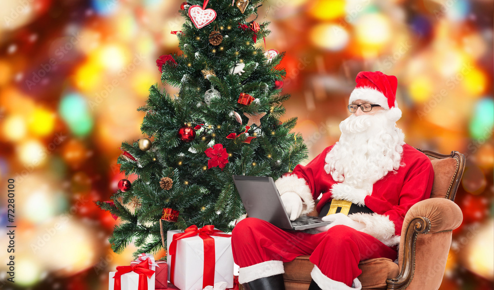 man in costume of santa claus with laptop