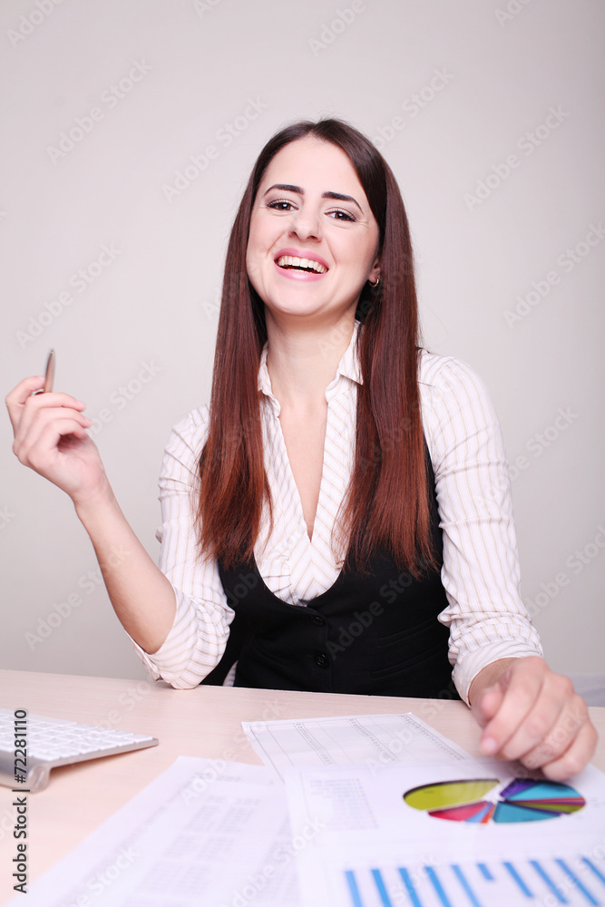 Portrait of a smiling mature businesswoman at office desk with a Portrait of a smiling mature businesswoman at office desk with a