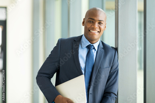 afro american businessman holding laptop computer