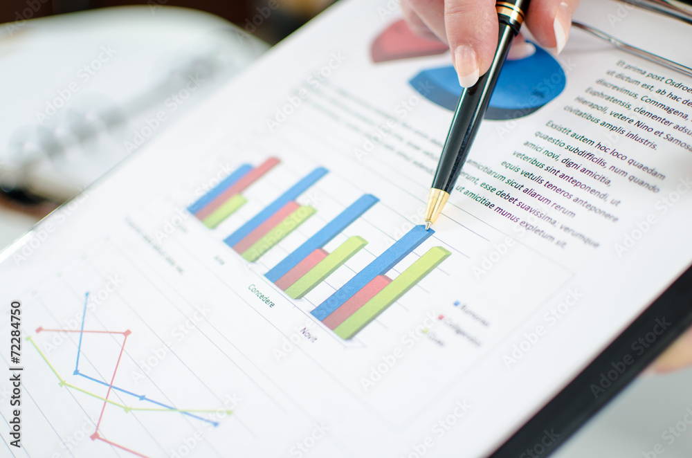 Assistant showing graphs to her boss Assistant showing graphs to her boss
