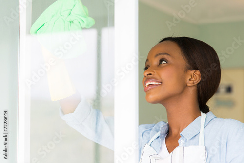 african woman cleaning window glass
