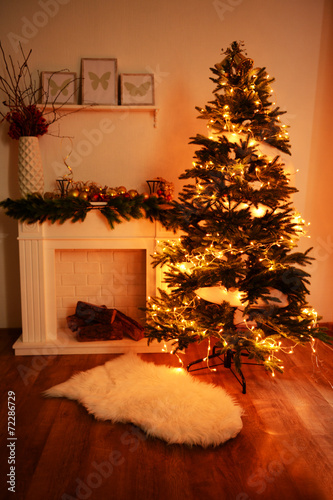 Christmas tree near fireplace in room