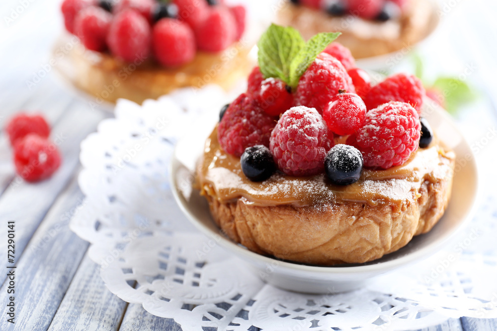 Sweet cakes with berries on table close-up Sweet cakes with berries on table close-up