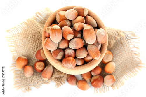 Hazelnuts in wooden bowl isolated on white