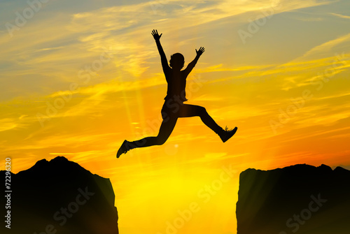 Young person jumping over the mountains