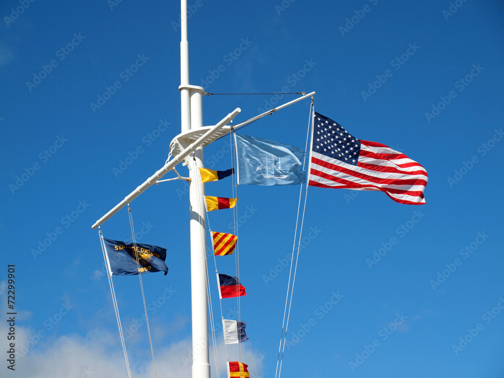 Nautical and American Flags Hanging from a Ship's Mast with Wisp