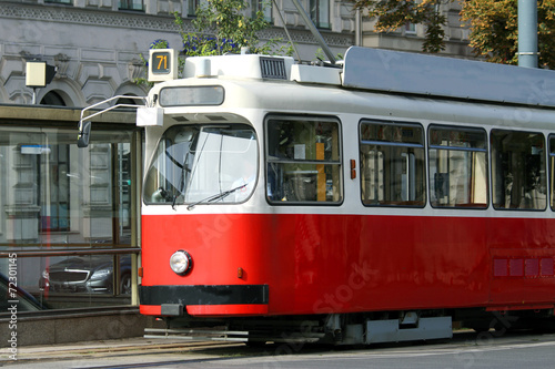 red tram carries passengers for European cities