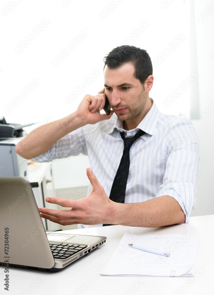 Businessman with laptop talkng on the phone