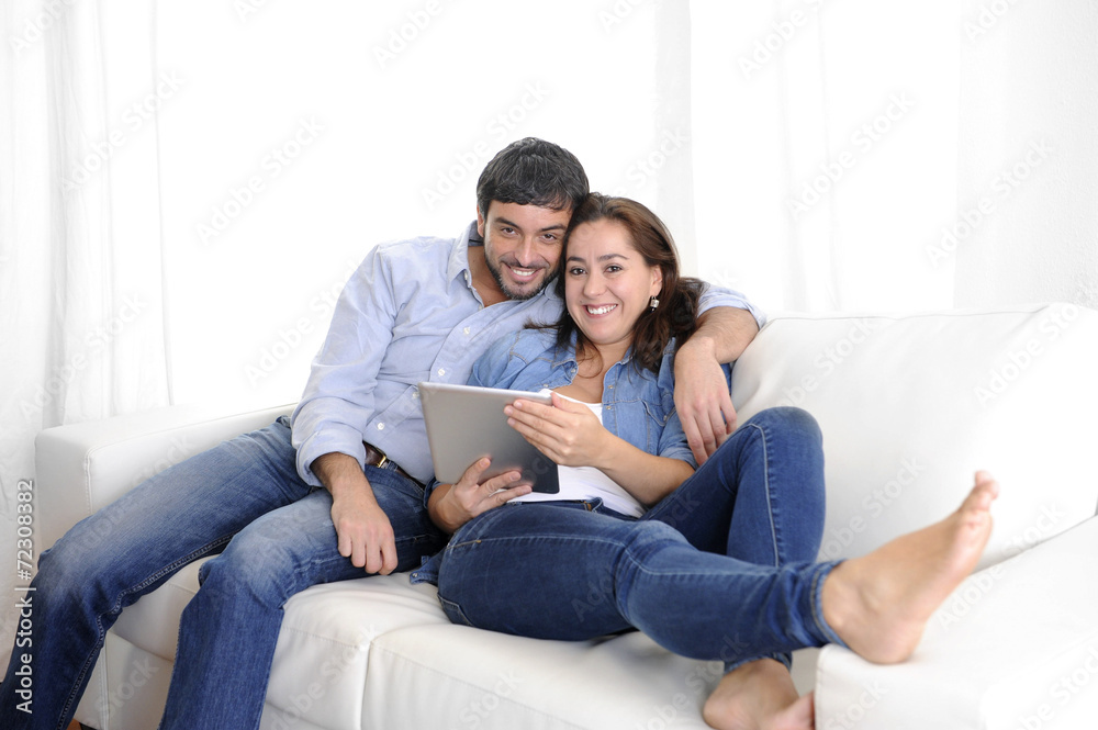 young happy couple on couch enjoying digital tablet computer young happy couple on couch enjoying digital tablet computer