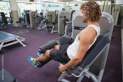 Side view of man doing leg workout at gym