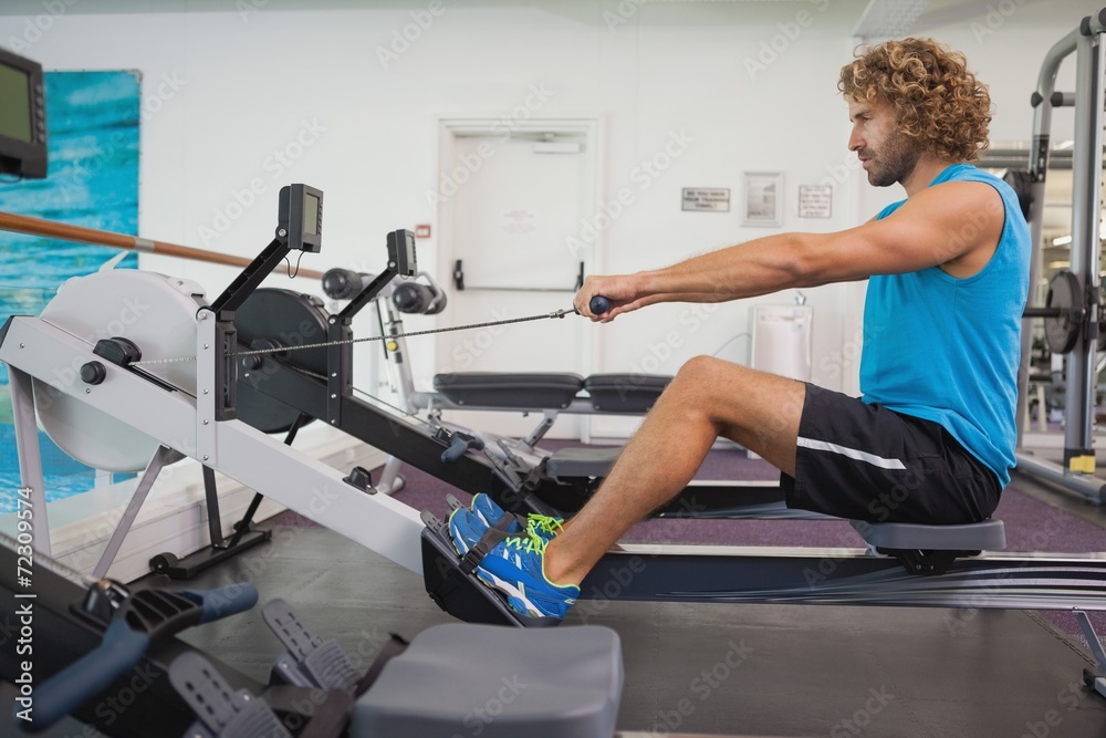 Side view of man using resistance band in gym Side view of man using resistance band in gym