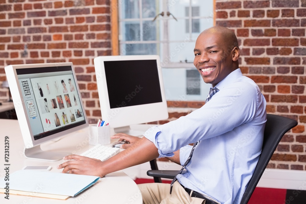 Obraz premium Smiling photo editor using computer in office