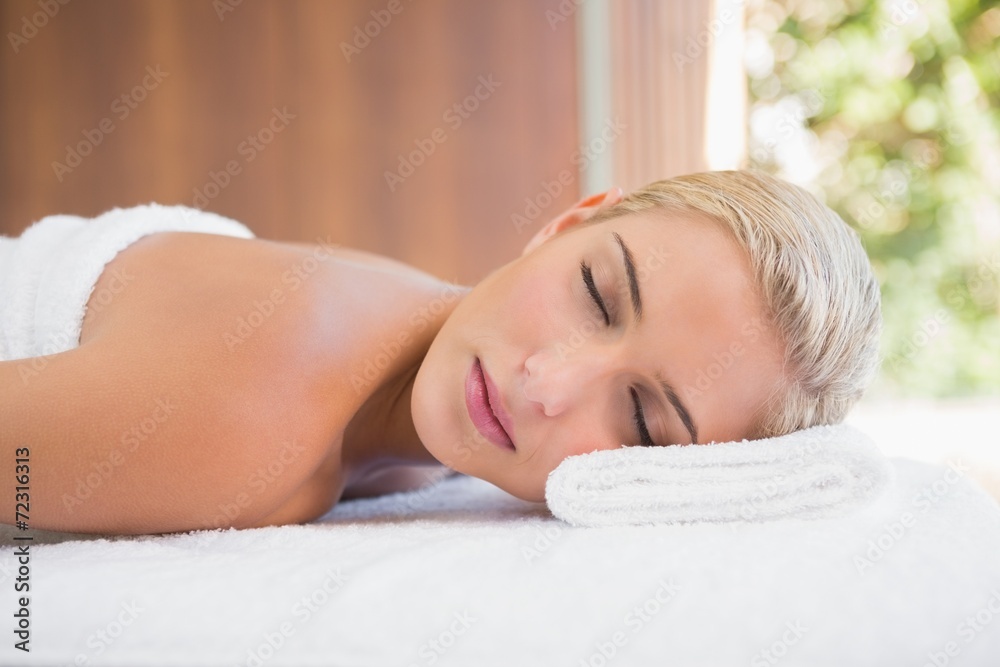 Beautiful woman lying on massage table at spa center Beautiful woman lying on massage table at spa center