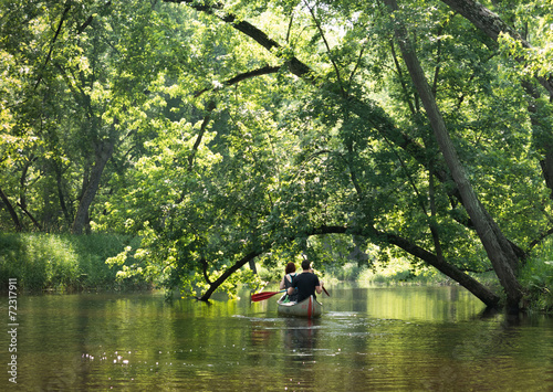 Young couple canoeing on still backwater