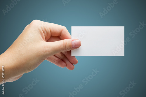 hand holding a white business card on a blue background