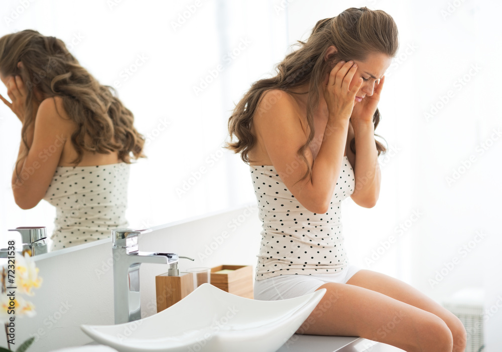 Stressed young woman sitting in bathroom Stressed young woman sitting in bathroom