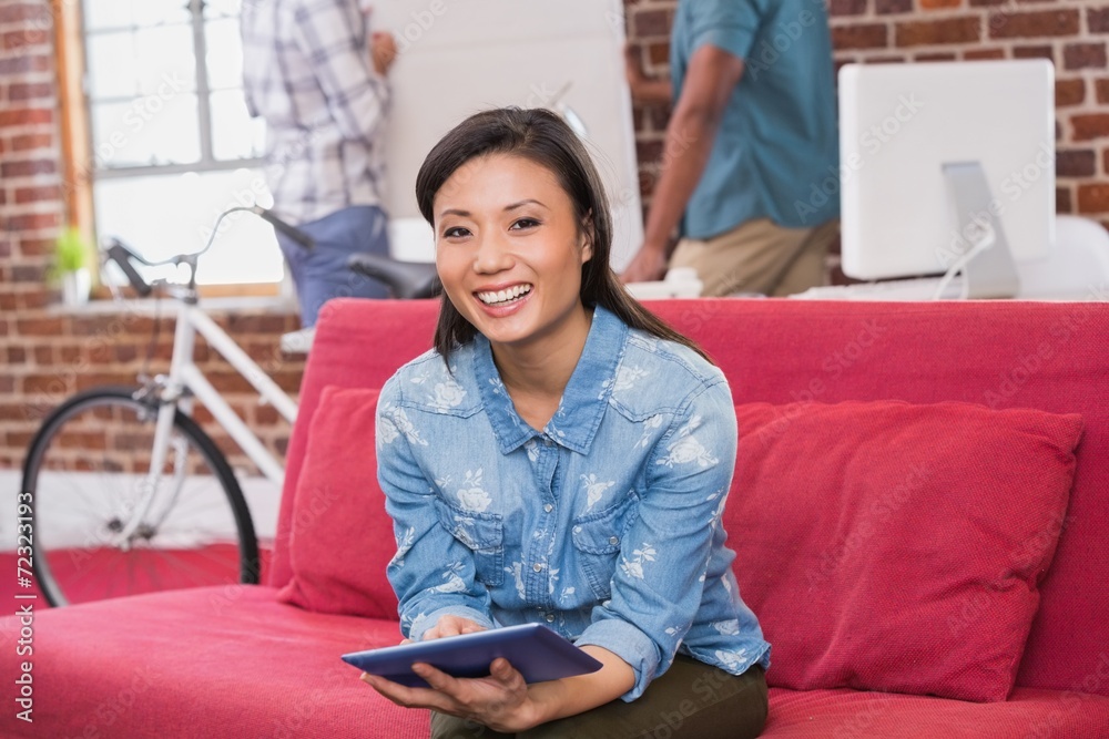 Casual woman using digital tablet on couch Casual woman using digital tablet on couch