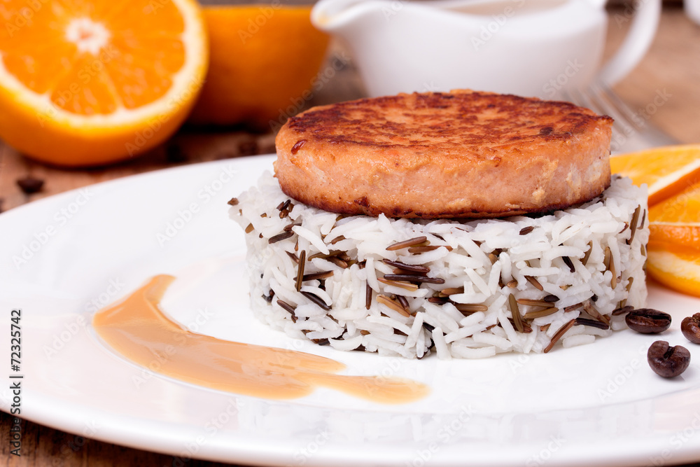Salmon medallion with mixed cooked rice on white plate
