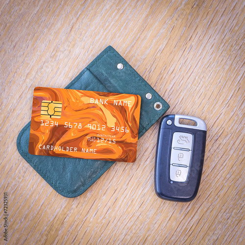 Car key with remote control and credit card on the wooden table