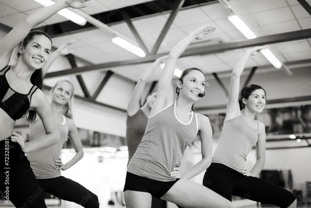 group of smiling people stretching in the gym group of smiling people stretching in the gym