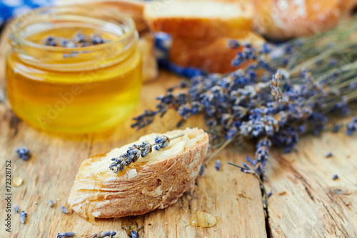 Bread and jar of honey with lavender flowers