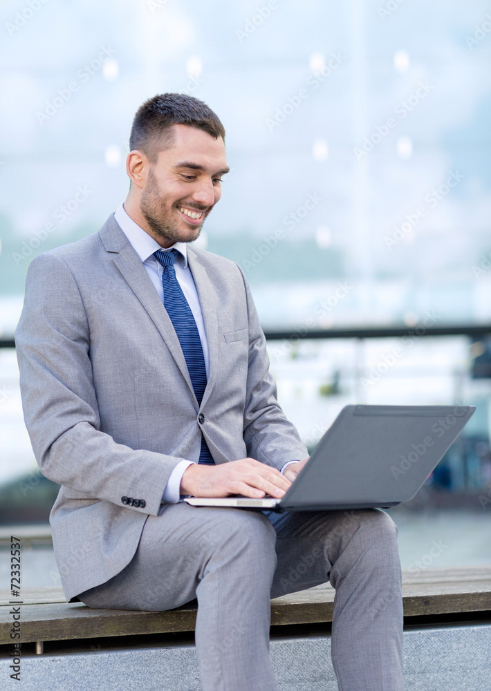 smiling businessman working with laptop outdoors smiling businessman working with laptop outdoors