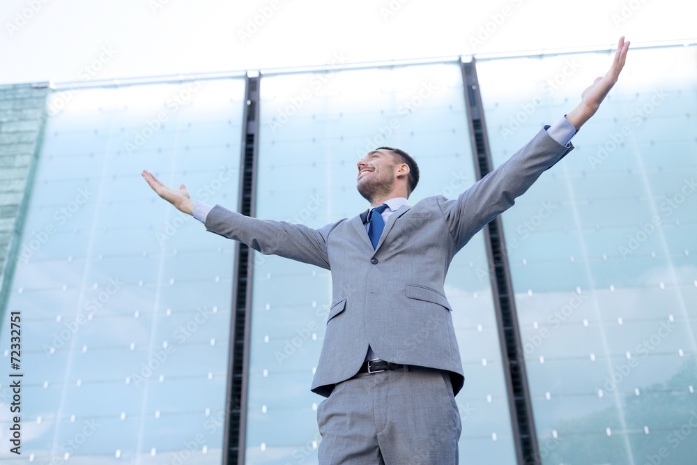 young smiling businessman over office building